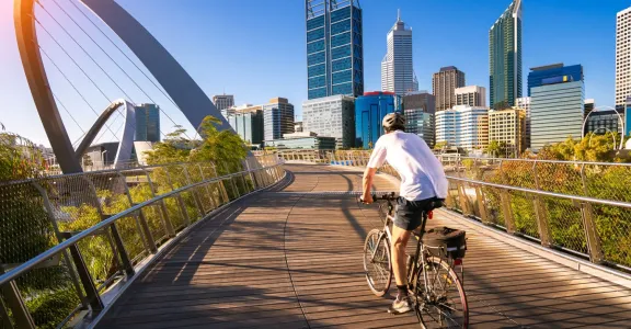 Un homme à vélo sur un pont au-dessus d'une ville.