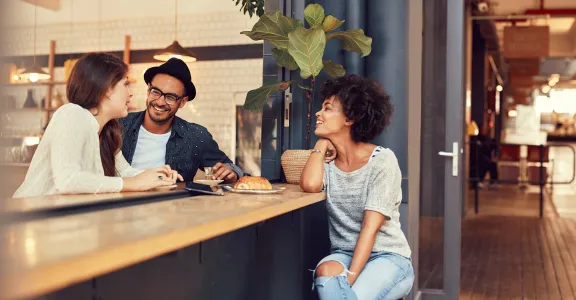 Trois amis appréciant un repas ensemble dans un restaurant confortable.