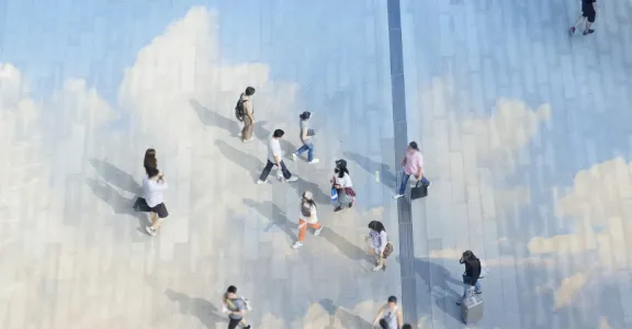 Gens marchant sur un bâtiment avec des nuages peints.
